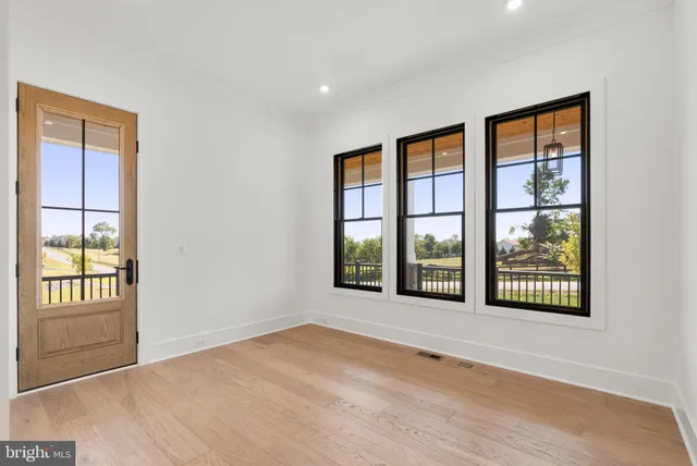 a view of an empty room with a window and a kitchen