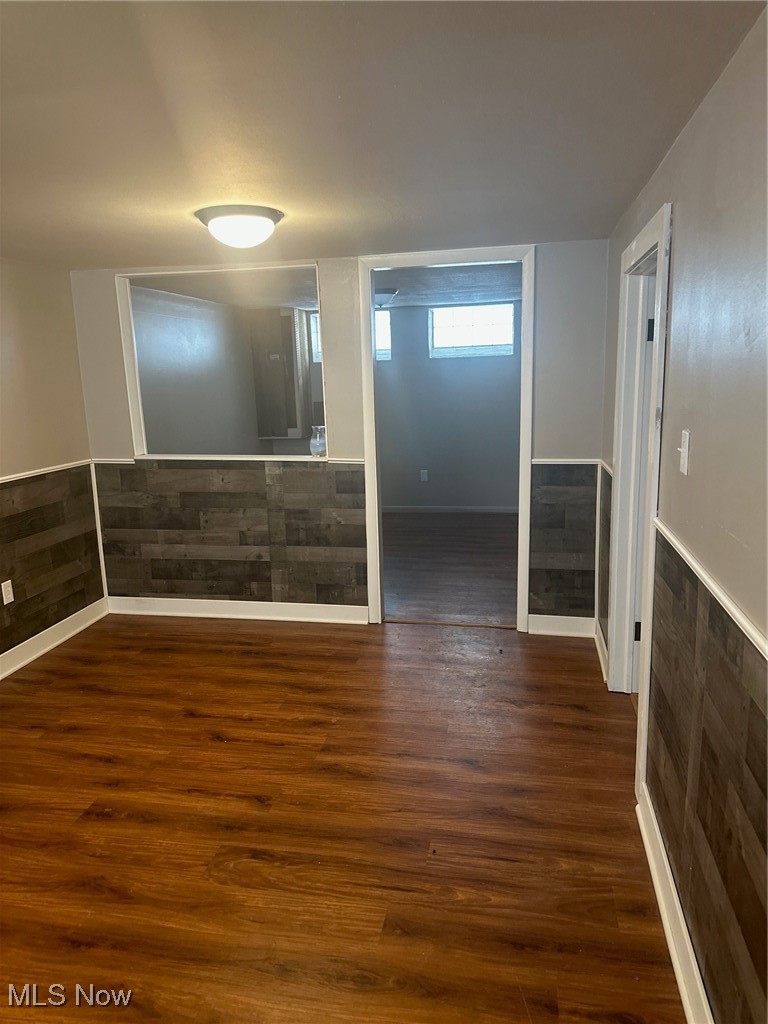 12926 Littleton Road Garfield Heights, OH 44125 - Photo 6 of 12 Empty room with dark wood-type flooring and wooden walls