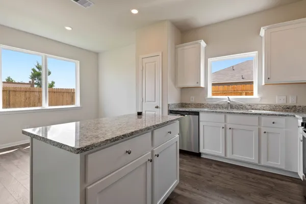 a kitchen with granite countertop cabinets stainless steel appliances a sink and a window