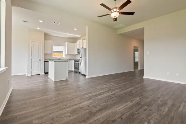 a view of a kitchen with wooden floor a sink and a refrigerator