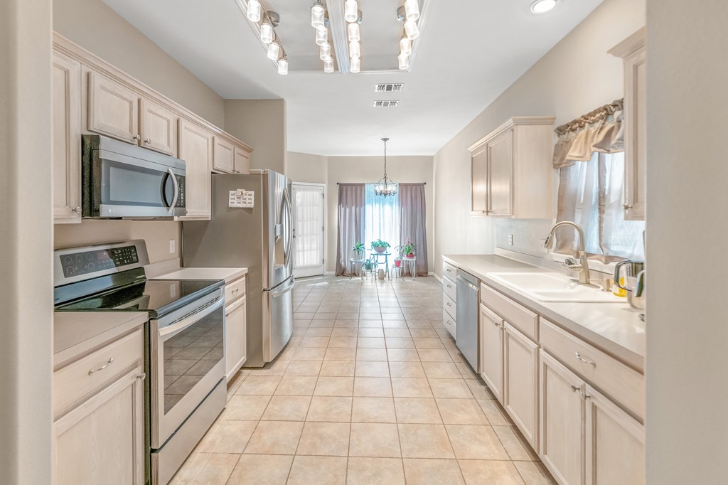 225 Los Cedros Loop Kerrville, TX 78028 - Photo 4 of 27 a large kitchen with a stove top oven a sink dishwasher and a refrigerator