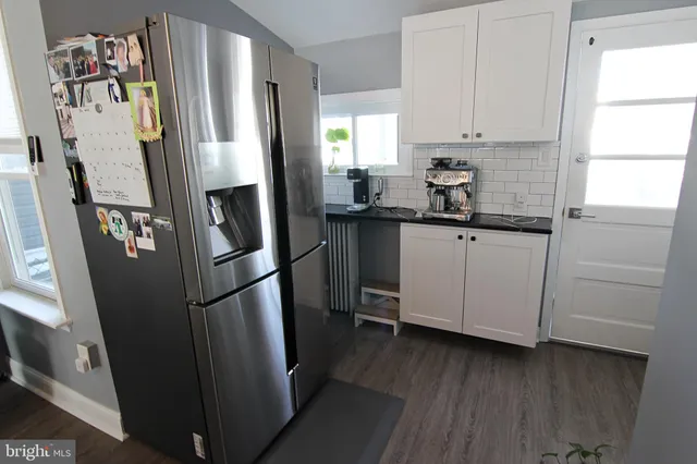 a kitchen with stainless steel appliances a refrigerator sink and wooden floor