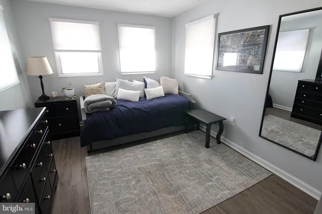 a bedroom with a bed window and mirror