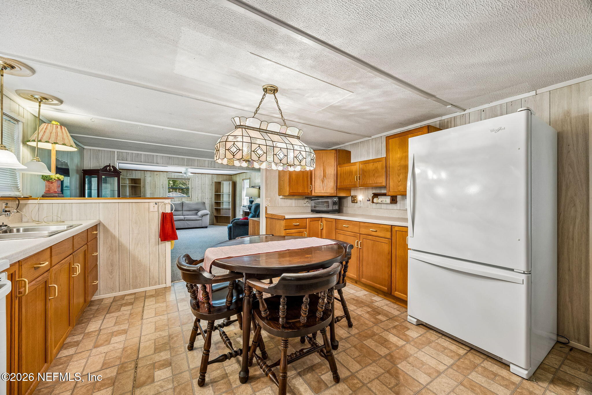 15690 Sears Road Jacksonville, FL 32218 - Photo 11 of 27 a kitchen with stainless steel appliances a dining table chairs and refrigerator