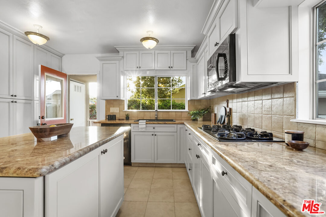 10129 Plainview Avenue Tujunga, CA 91042 - Photo 16 of 51 a kitchen with granite countertop a sink a stove and cabinets