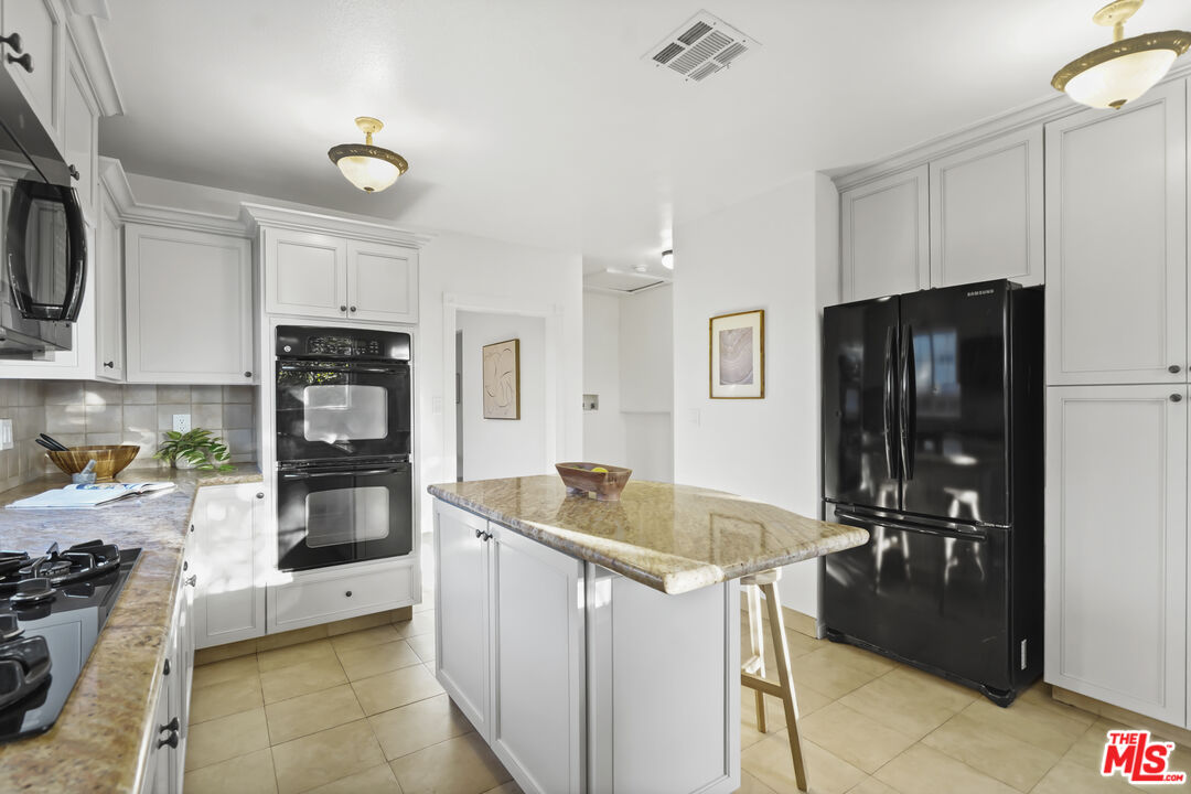 10129 Plainview Avenue Tujunga, CA 91042 - Photo 17 of 51 a kitchen with stainless steel appliances granite countertop a refrigerator and a stove top oven