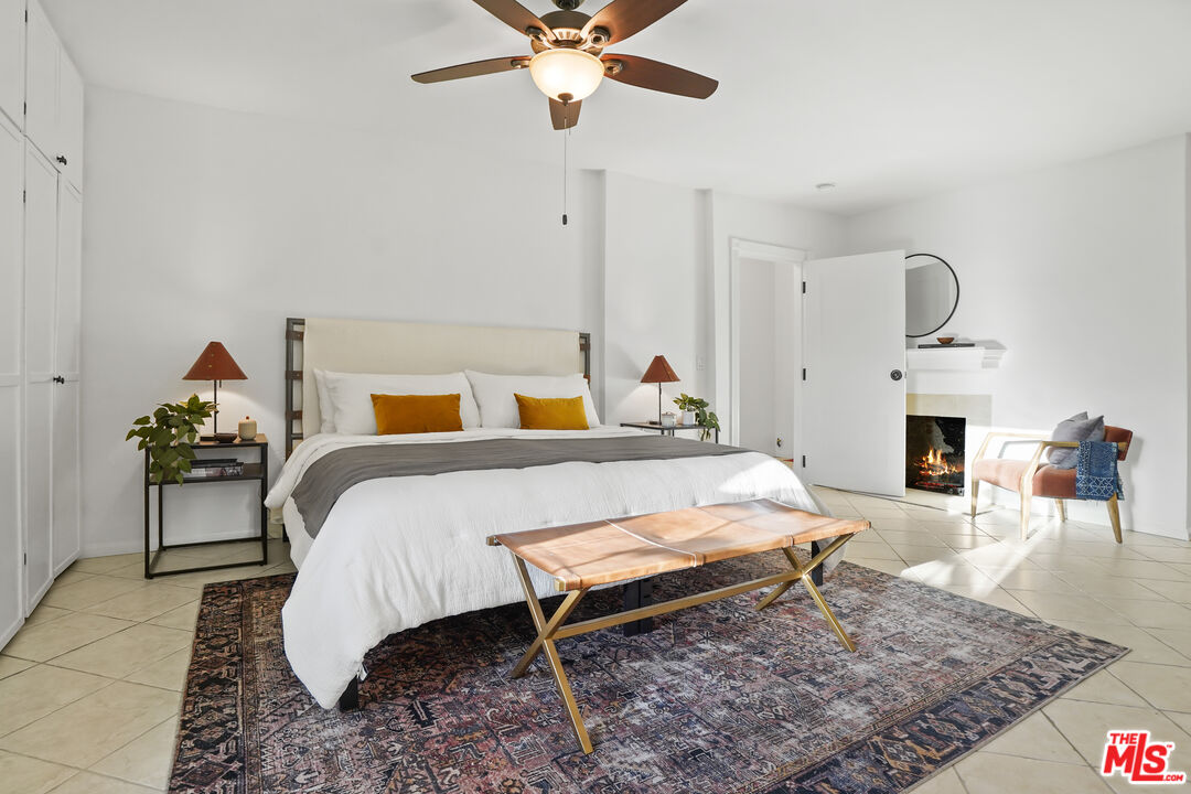 10129 Plainview Avenue Tujunga, CA 91042 - Photo 23 of 51 a bedroom with a bed a fireplace and a chandelier