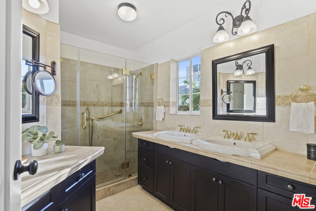 10129 Plainview Avenue Tujunga, CA 91042 - Photo 24 of 51 a bathroom with double vanity sinks a toilet a mirror and shower