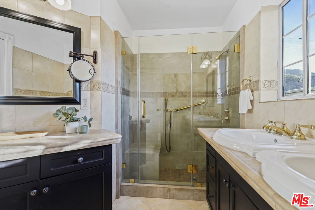 10129 Plainview Avenue Tujunga, CA 91042 - Photo 25 of 51 a bathroom with a shower sink and mirror