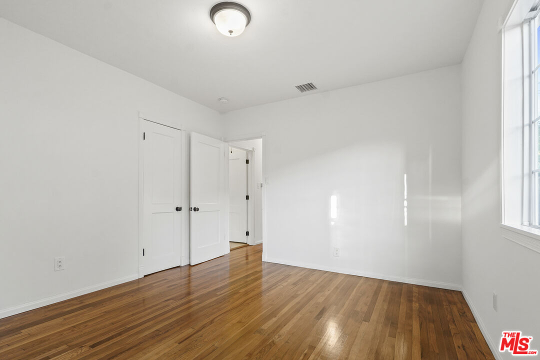 10129 Plainview Avenue Tujunga, CA 91042 - Photo 28 of 51 a view of an empty room with wooden floor and a window
