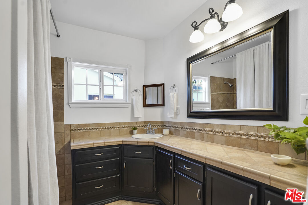 10129 Plainview Avenue Tujunga, CA 91042 - Photo 32 of 51 a bathroom with a sink and two mirror
