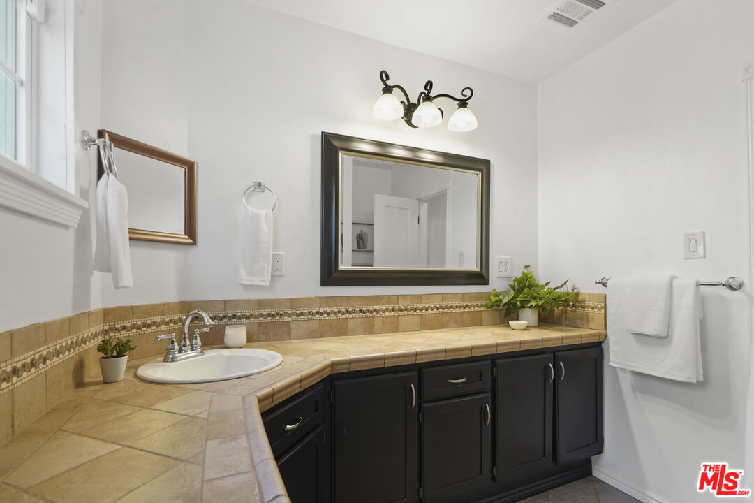 10129 Plainview Avenue Tujunga, CA 91042 - Photo 33 of 51 a bathroom with a sink and a mirror