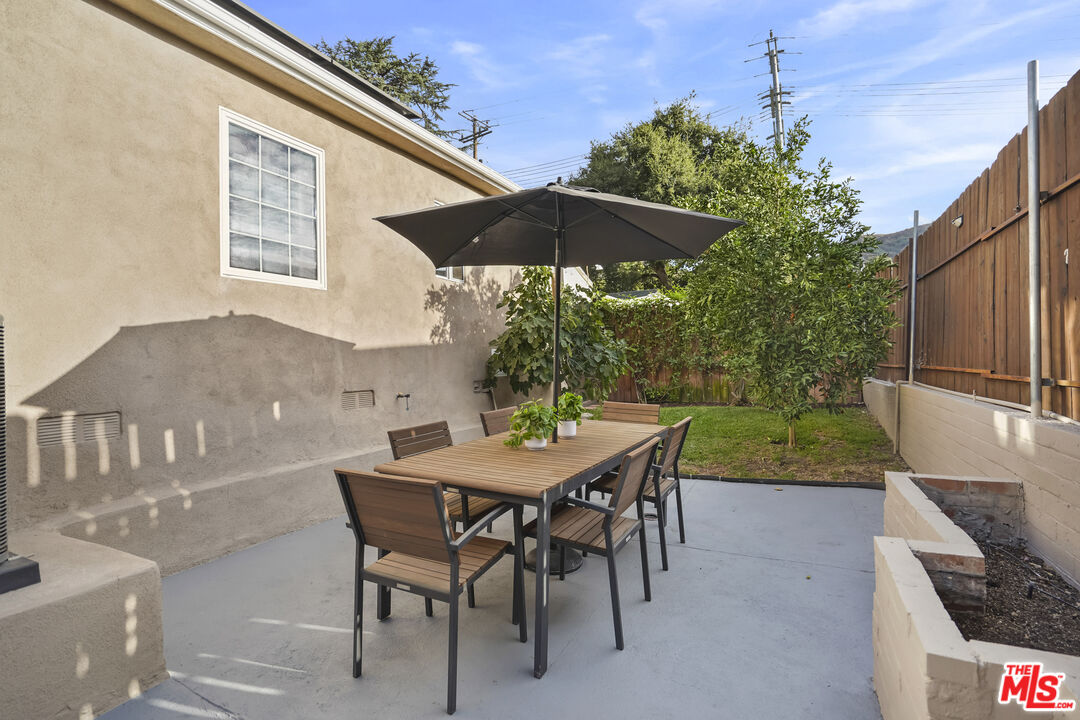 10129 Plainview Avenue Tujunga, CA 91042 - Photo 36 of 51 a patio with a table and chairs under an umbrella