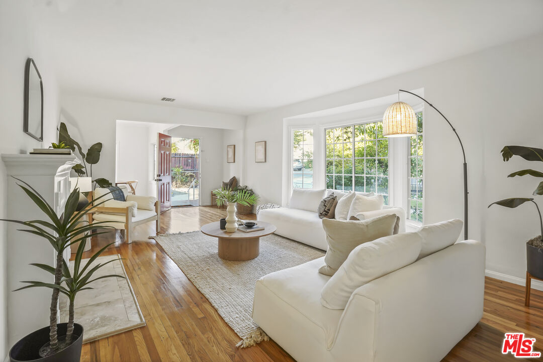 10129 Plainview Avenue Tujunga, CA 91042 - Photo 9 of 51 a living room with furniture a large window and wooden floor