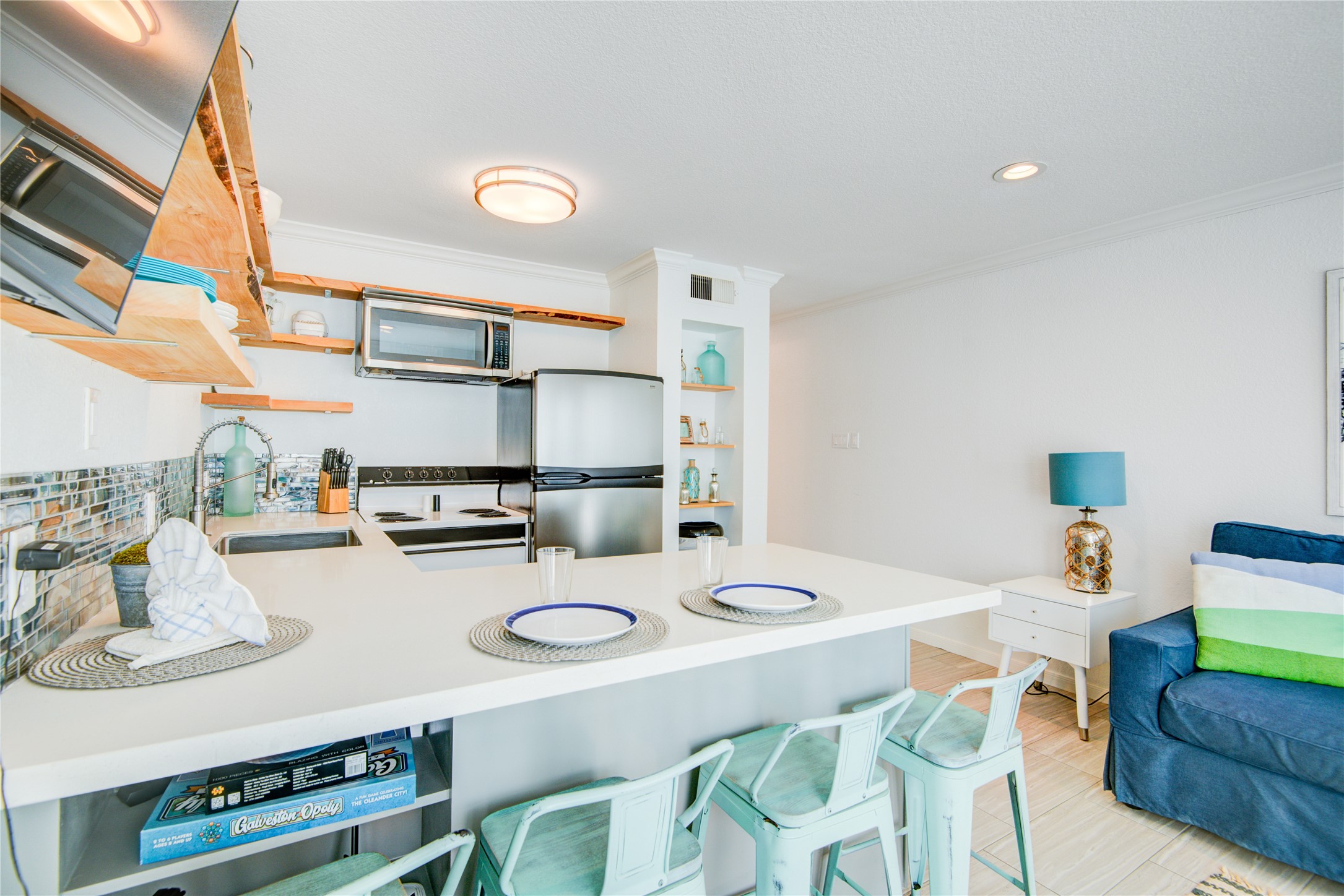 10811 Termini-San Luis Pass Road, Unit 2307 Galveston, TX 77554 - Photo 15 of 32 a kitchen with kitchen island a stove a table and chairs