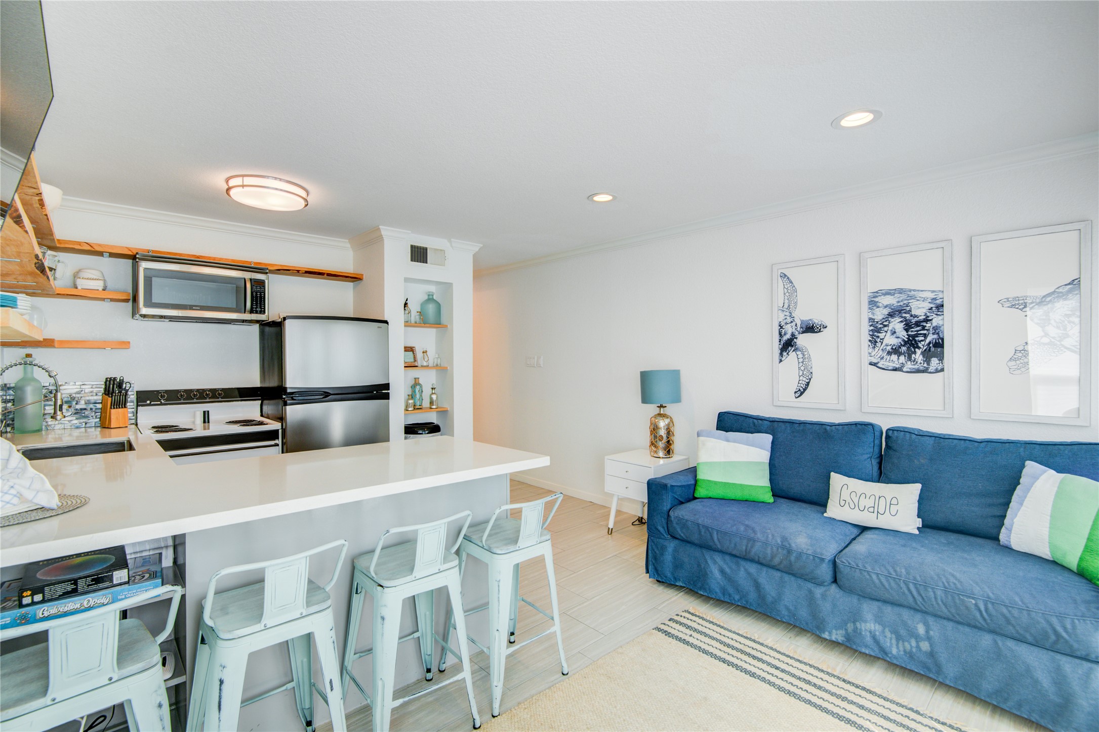 10811 Termini-San Luis Pass Road, Unit 2307 Galveston, TX 77554 - Photo 18 of 32 a living room with stainless steel appliances kitchen island a table and chairs