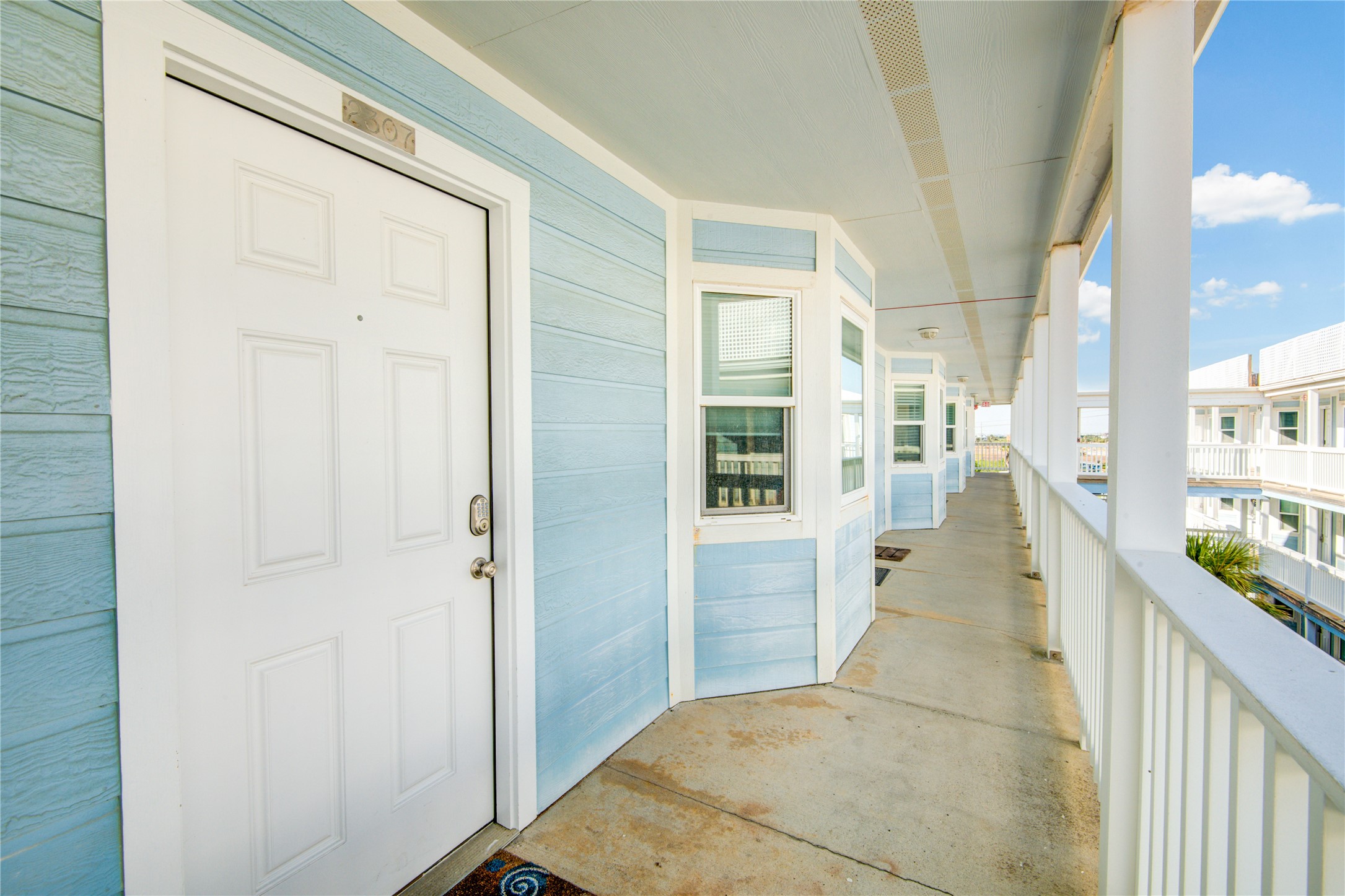 10811 Termini-San Luis Pass Road, Unit 2307 Galveston, TX 77554 - Photo 2 of 32 a view of a hallway with wooden floor and staircase