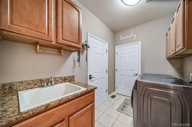 a bathroom with a granite countertop sink and a washing machine