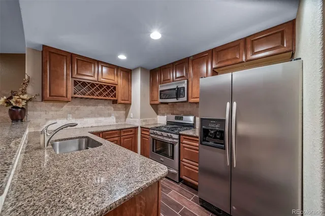 a kitchen with kitchen island a counter top space cabinets stainless steel appliances and a counter space