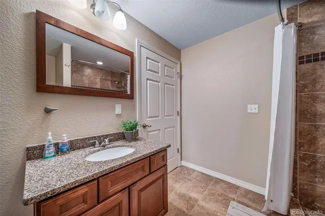 a bathroom with a granite countertop sink and a mirror