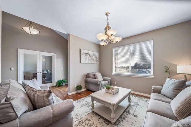 a living room with furniture chandelier and a table