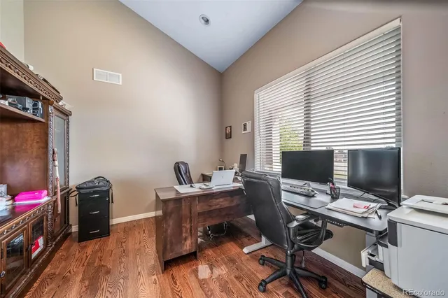 a view of a workspace with furniture and a window