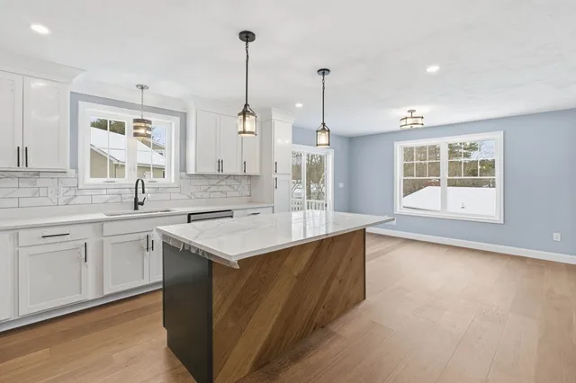 a kitchen with stainless steel appliances granite countertop a sink a stove and a window