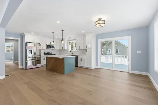 a view of kitchen with stainless steel appliances granite countertop a stove top oven a sink and a refrigerator