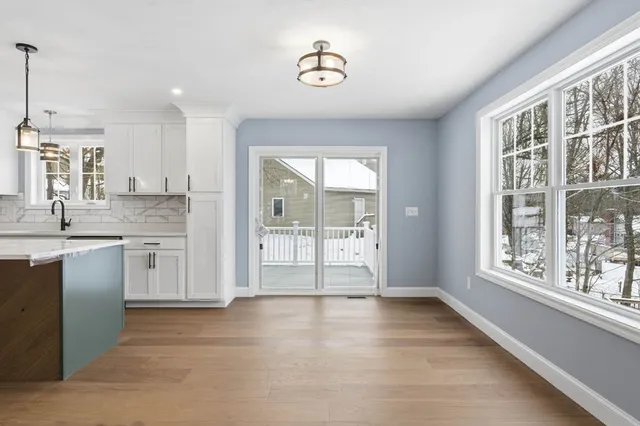 a view of a kitchen with a sink and dishwasher with wooden floor