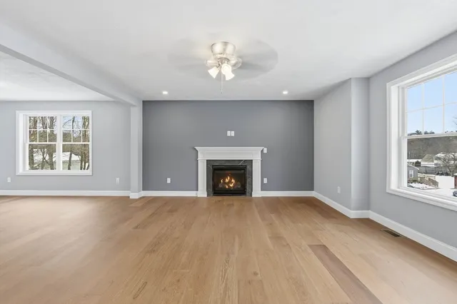 a view of an empty room with a window and fireplace