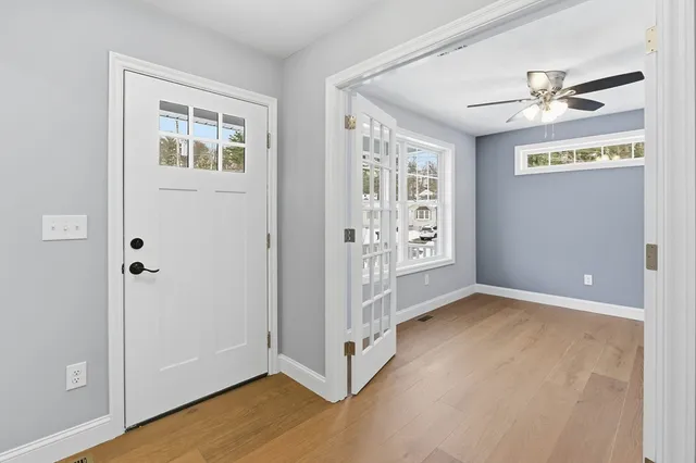 a view of an empty room with window and wooden floor