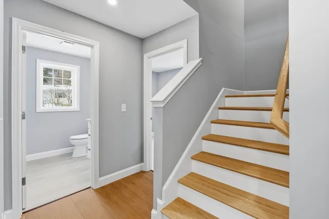 a view of an entryway with wooden floor and a bathroom