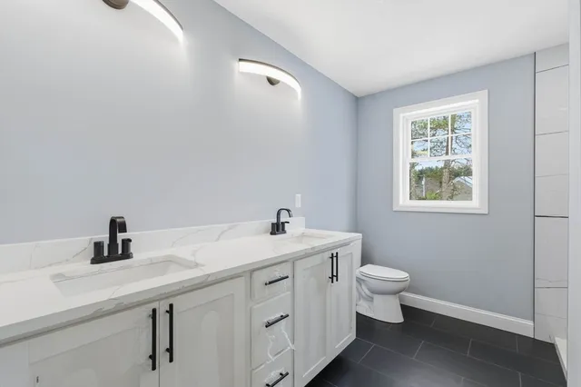 a bathroom with a toilet sink and mirror