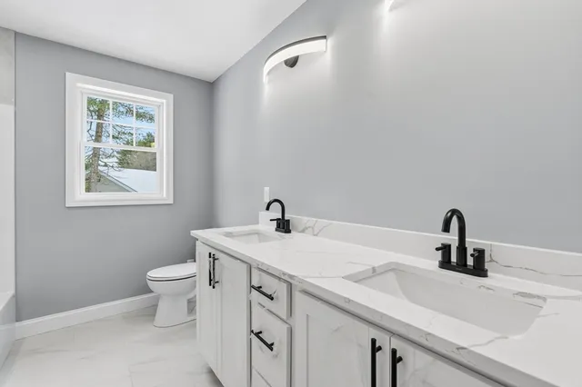 a bathroom with a sink toilet and a window