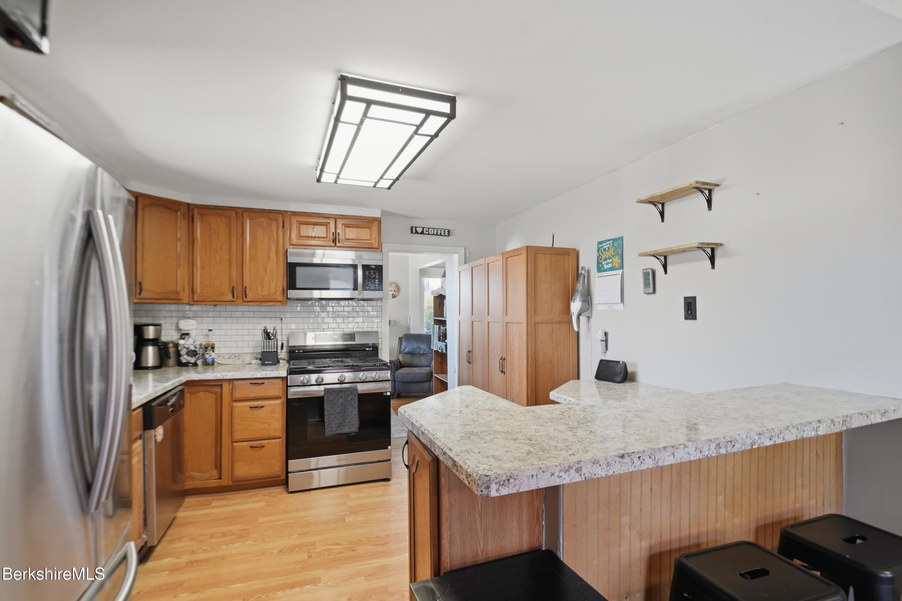 22 Broadway Street Pittsfield, MA 01201 - Photo 48 of 84 a kitchen with stainless steel appliances granite countertop a sink refrigerator and cabinets