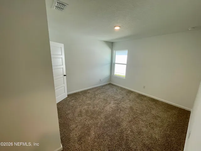 a view of a balcony with furniture and floor to ceiling window