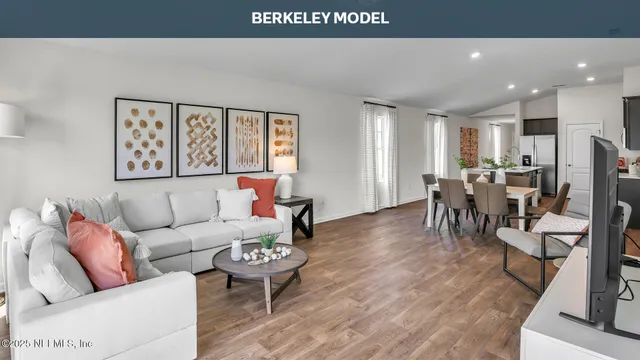 a living room with furniture kitchen view and a large window