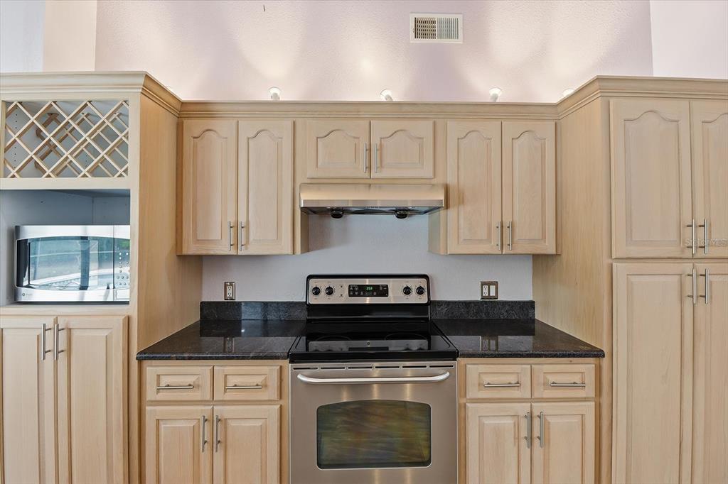 22 Mastic Court West Homosassa, FL 34446 - Photo 18 of 46 a kitchen with granite countertop white cabinets and a stove top oven