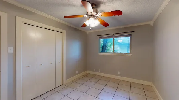 an empty room with windows and fan