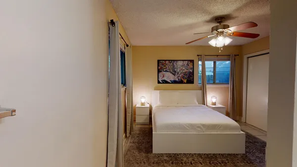 a bedroom with a large bed and a chandelier