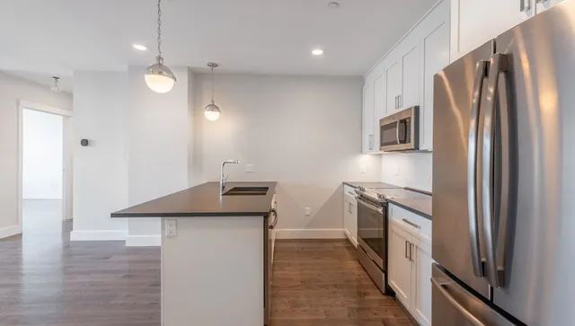 a kitchen with granite countertop a refrigerator and a sink