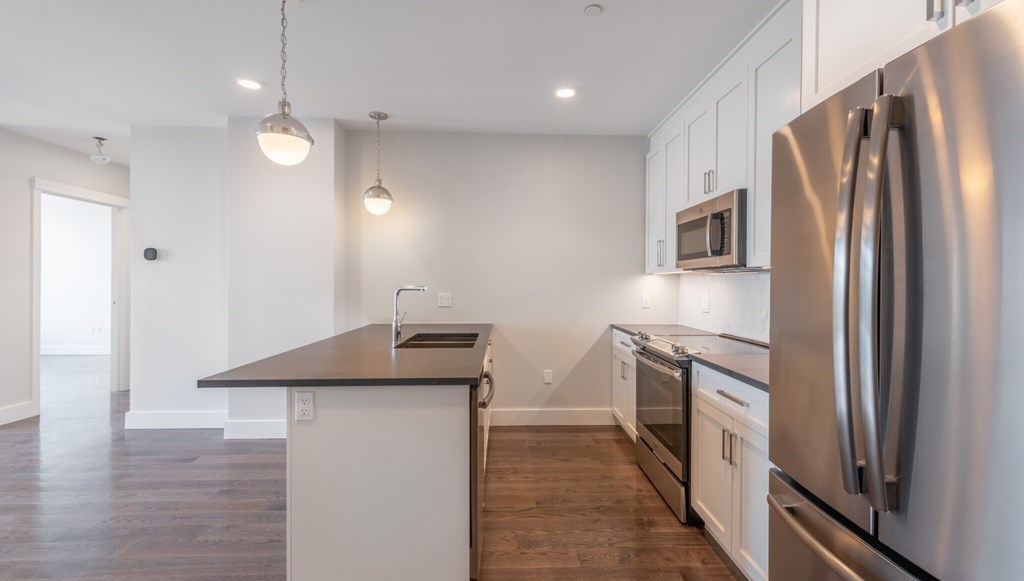 a kitchen with granite countertop a refrigerator and a sink