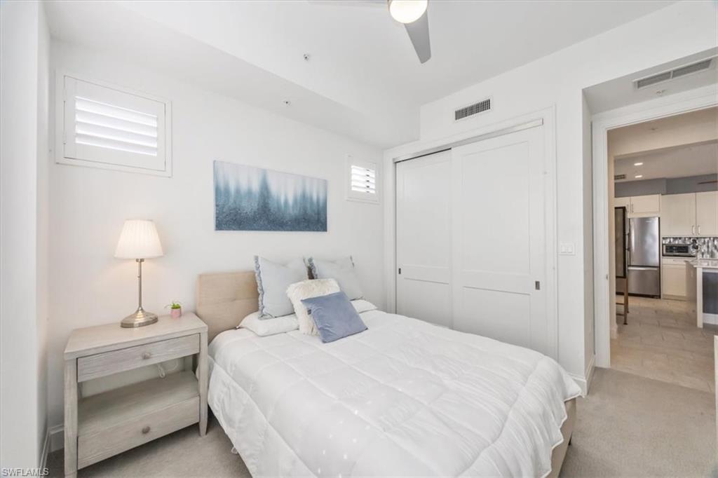 1111 Central Avenue, Unit 401 Naples, FL 34102 - Photo 12 of 36 a bedroom with a bed and a lamp