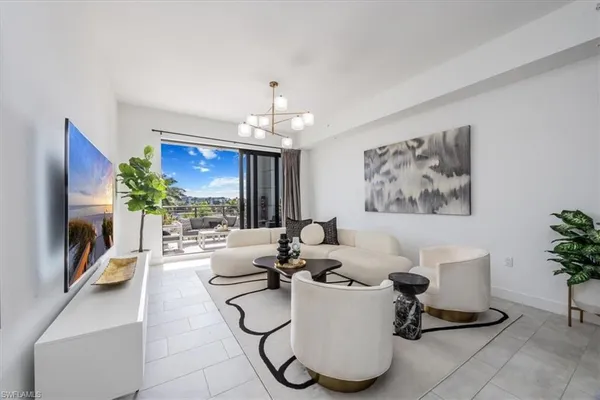 a living room with furniture a chandelier and a flat screen tv