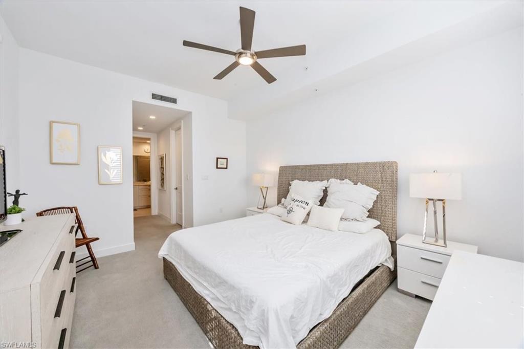 1111 Central Avenue, Unit 401 Naples, FL 34102 - Photo 20 of 36 a bedroom with a bed and a ceiling fan