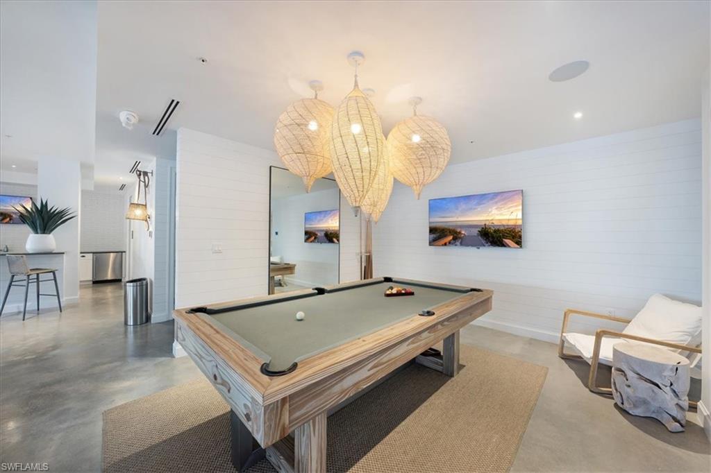 1111 Central Avenue, Unit 401 Naples, FL 34102 - Photo 23 of 36 a room with pool table and a chandelier