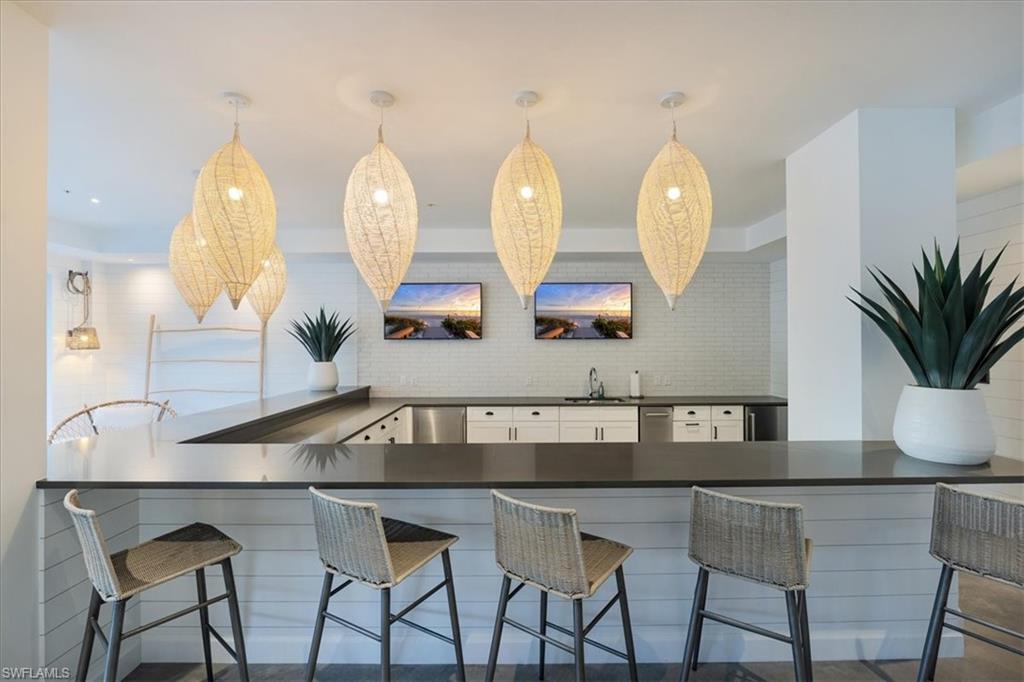 1111 Central Avenue, Unit 401 Naples, FL 34102 - Photo 25 of 36 a kitchen with a table chairs and chandelier