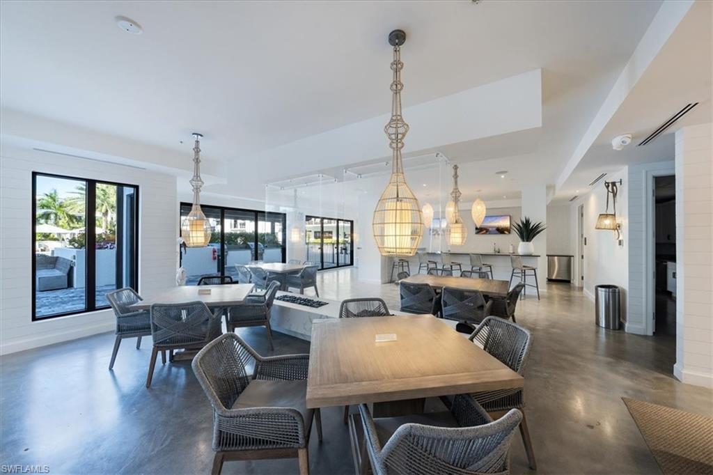 1111 Central Avenue, Unit 401 Naples, FL 34102 - Photo 26 of 36 a view of a dining room and livingroom with furniture wooden floor a chandelier