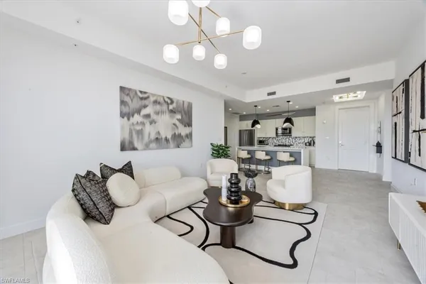 a living room with furniture a rug and a chandelier