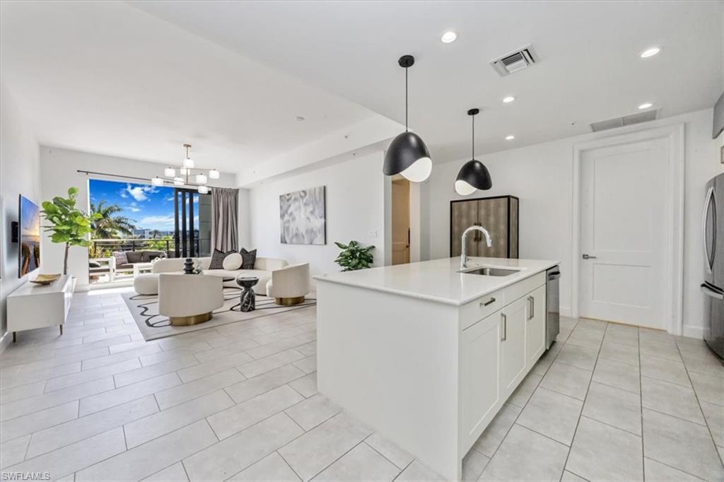 1111 Central Avenue, Unit 401 Naples, FL 34102 - Photo 35 of 36 a kitchen with stainless steel appliances kitchen island granite countertop a sink and a refrigerator